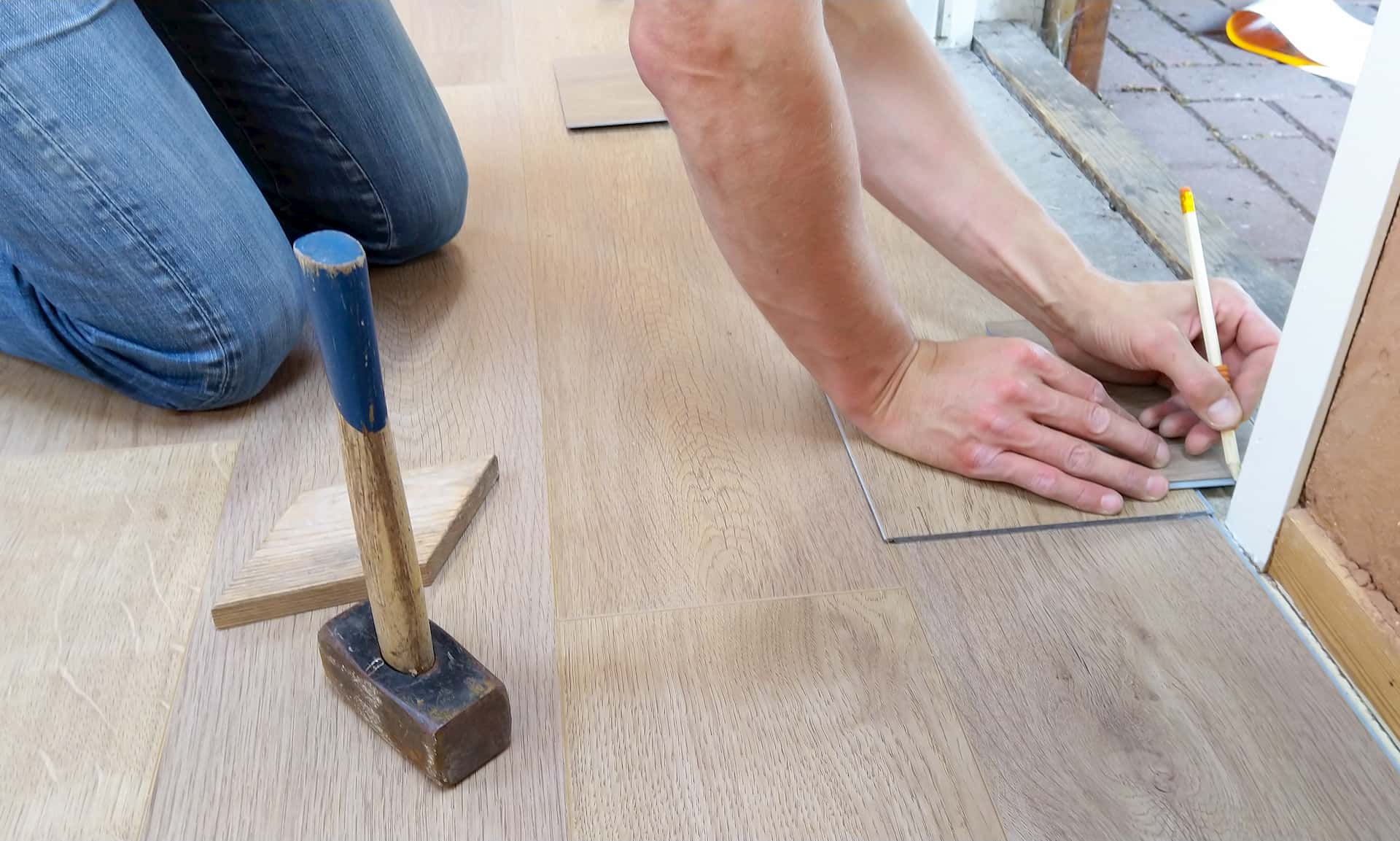 Aufarbeitung - Mann repariert einen Holzboden.